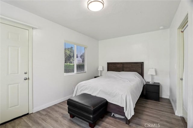 bedroom featuring baseboards and wood finished floors