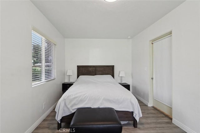 bedroom with baseboards and wood finished floors