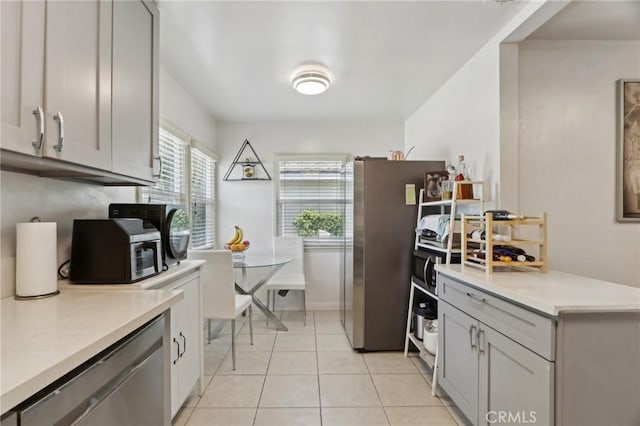 kitchen with light countertops, stainless steel appliances, gray cabinets, and light tile patterned floors