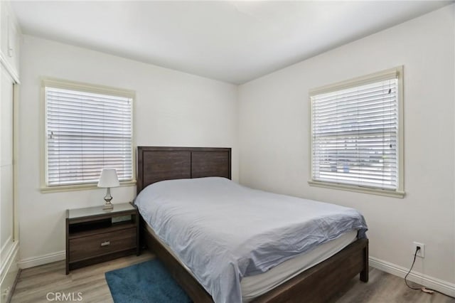 bedroom with baseboards and wood finished floors