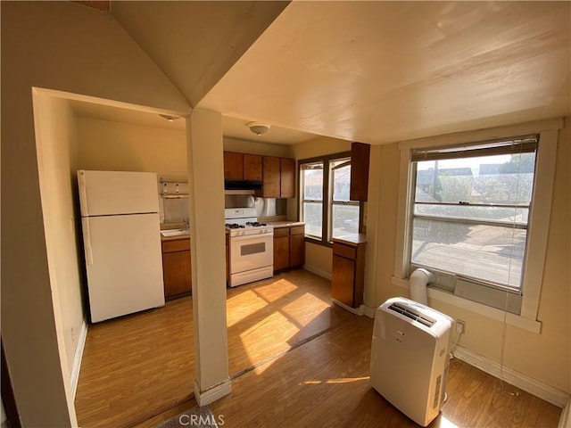 3755 Brockton Ave Unit 1-4, Riverside, CA 92501 - kitchen featuring brown cabinetry, white appliances, baseboards, under cabinet range hood, and light wood finished floors