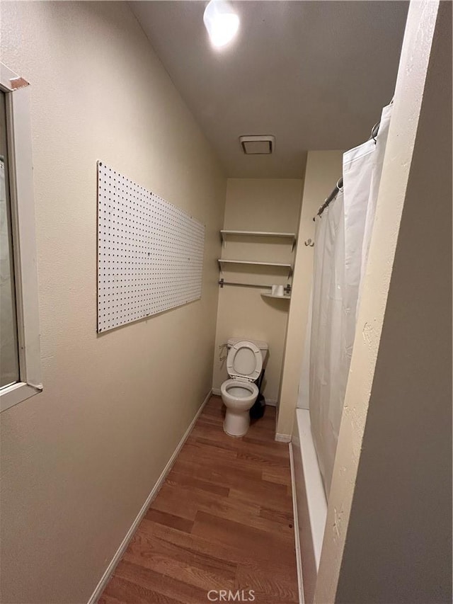 3755 Brockton Ave Unit 1-4, Riverside, CA 92501 - bathroom featuring baseboards, wood finished floors, toilet, and curtained shower
