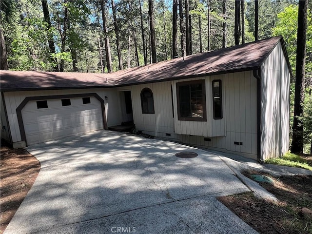 view of front of property featuring crawl space, driveway, roof with shingles, and a garage