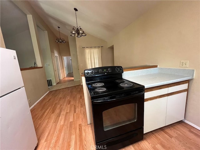 kitchen featuring white cabinets, an inviting chandelier, light wood-style flooring, freestanding refrigerator, and black range with electric stovetop