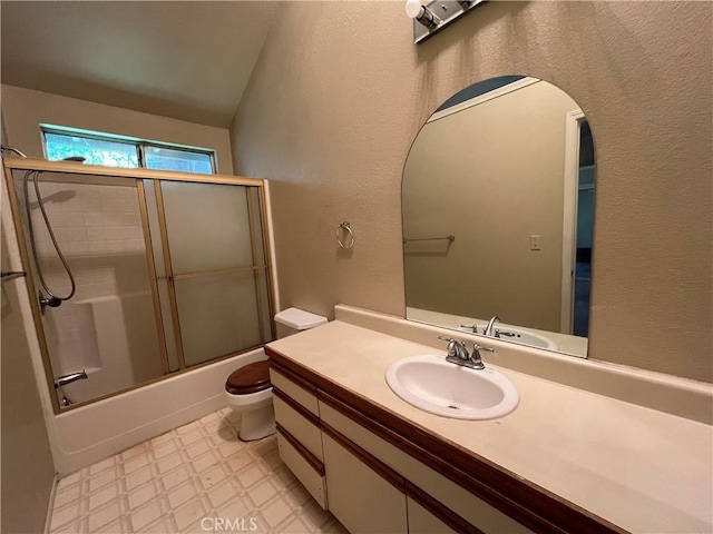 full bathroom featuring vanity, a textured wall, toilet, tile patterned floors, and enclosed tub / shower combo