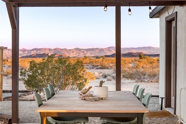 view of patio with outdoor dining area and a mountain view