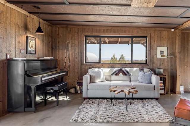 living area featuring concrete floors and wooden walls