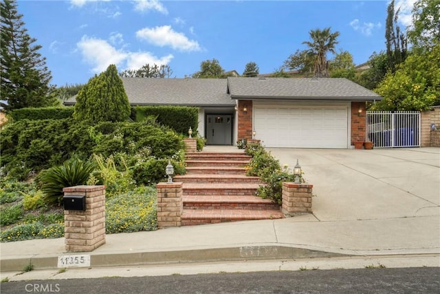 view of front of property featuring fence, roof with shingles, brick siding, a garage, and driveway