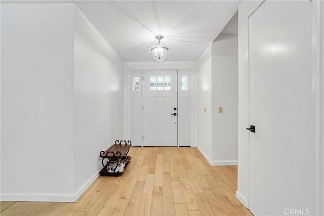 entrance foyer featuring baseboards, light wood finished floors, and an inviting chandelier