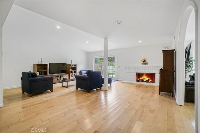 living room featuring a fireplace, recessed lighting, and light wood-type flooring