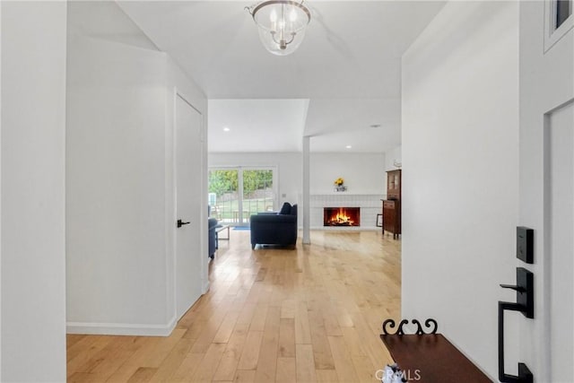 hallway with baseboards, recessed lighting, and light wood-style flooring