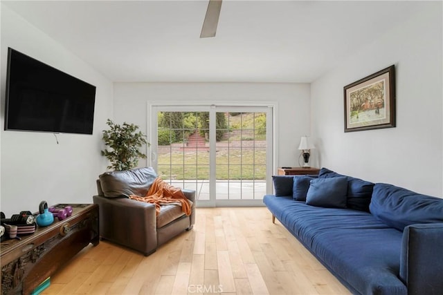 living area with light wood-type flooring and a ceiling fan