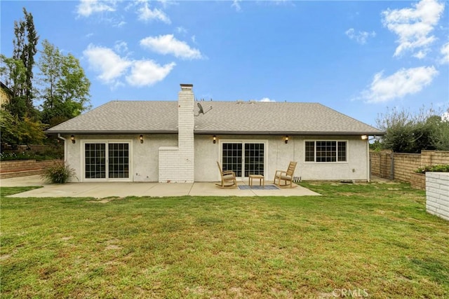 back of property featuring a lawn, a patio area, stucco siding, and fence