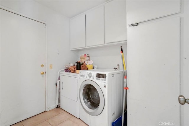 laundry room with cabinet space, light tile patterned flooring, and washing machine and clothes dryer