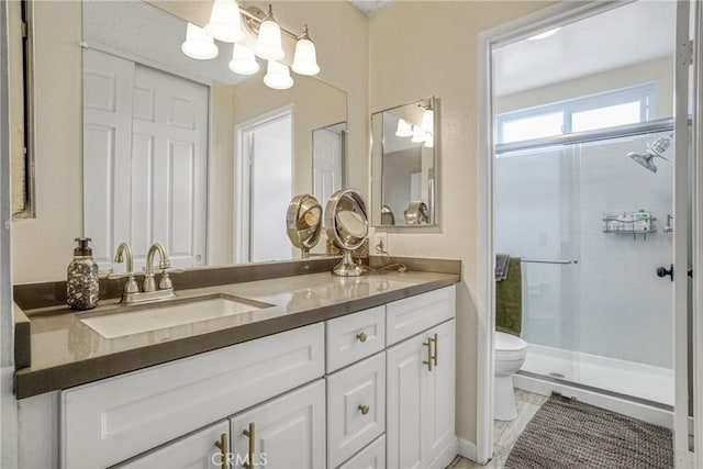 full bathroom featuring double vanity, toilet, a chandelier, a shower stall, and a sink