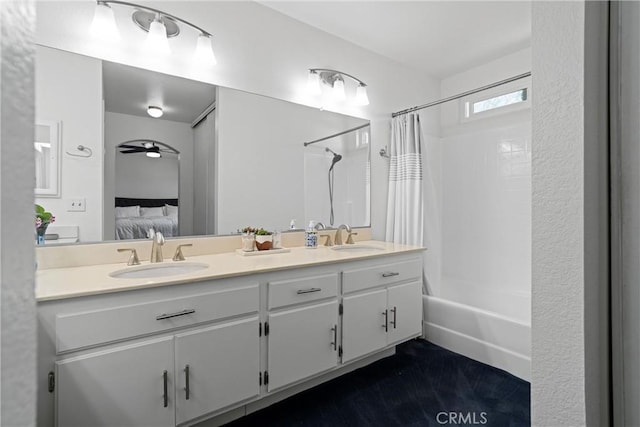 ensuite bathroom with ensuite bathroom, a sink, shower / bathtub combination with curtain, and double vanity