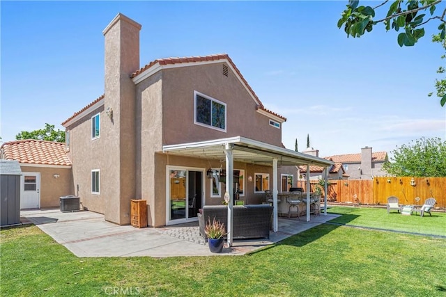 rear view of house featuring fence, a patio, stucco siding, a chimney, and a tile roof
