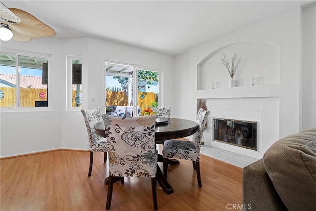 dining room with baseboards, a fireplace with flush hearth, and wood finished floors