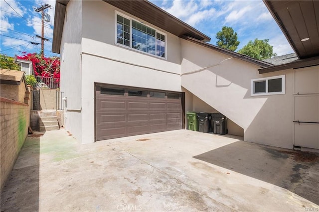 exterior space with an attached garage, stucco siding, and concrete driveway