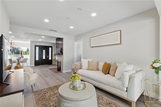 living area featuring recessed lighting, light wood-style floors, baseboards, and visible vents