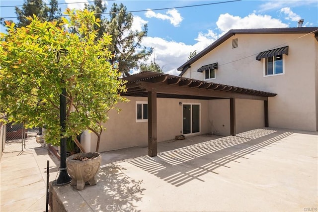 back of house featuring fence, a patio area, and stucco siding