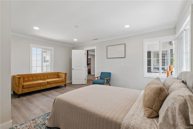 bedroom featuring visible vents, baseboards, light wood finished floors, ornamental molding, and recessed lighting