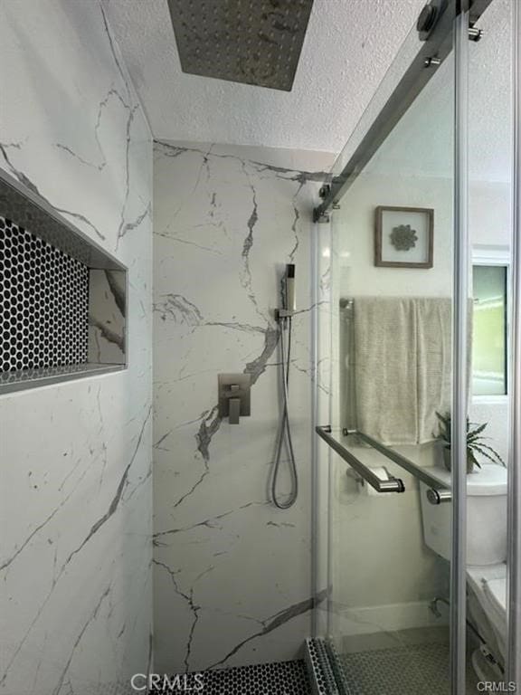 full bath featuring toilet and a marble finish shower