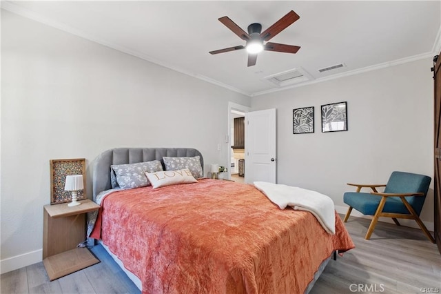bedroom featuring crown molding, attic access, baseboards, light wood-type flooring, and visible vents