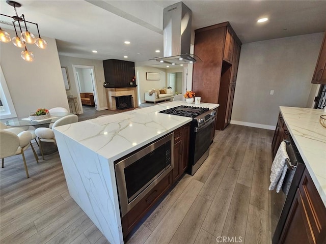 kitchen featuring recessed lighting, range with gas stovetop, ventilation hood, and stainless steel microwave
