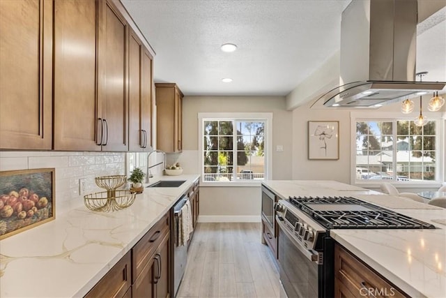 9951 Glencrest Cir, Sun Valley, CA 91504 - kitchen with appliances with stainless steel finishes, island range hood, a sink, light wood finished floors, and tasteful backsplash