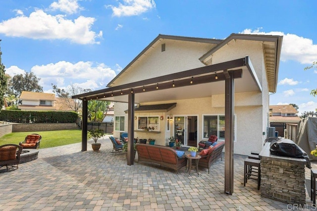 back of property featuring outdoor dry bar, an outdoor living space with a fire pit, stucco siding, a fenced backyard, and a patio