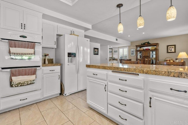 kitchen featuring pendant lighting, light tile patterned floors, white cabinets, tile counters, and white appliances