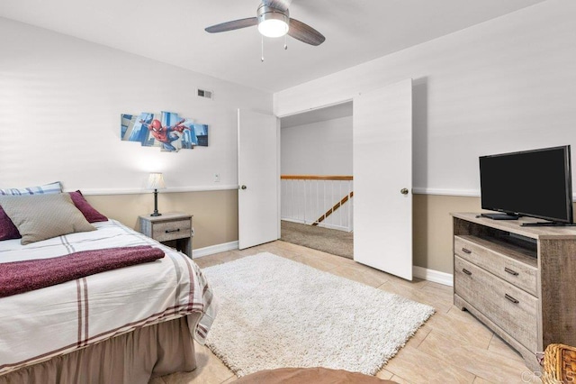bedroom with light tile patterned flooring, a ceiling fan, visible vents, and baseboards