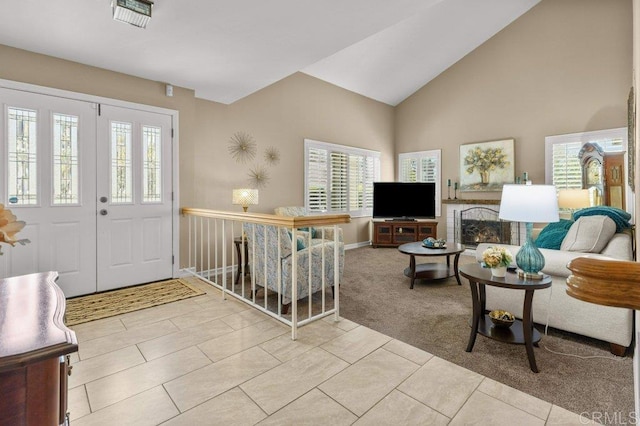 carpeted entryway with plenty of natural light, baseboards, and high vaulted ceiling