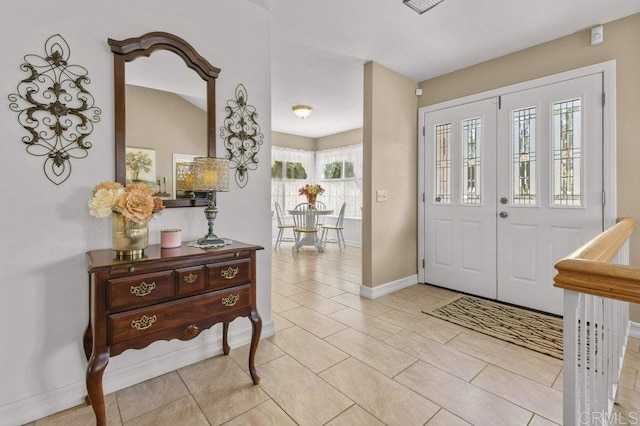 entryway with baseboards and light tile patterned floors