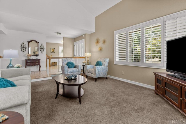 living room with baseboards, lofted ceiling, and carpet