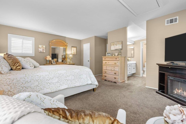bedroom with carpet flooring, a warm lit fireplace, visible vents, and baseboards