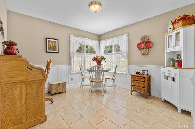 dining area with wainscoting and light tile patterned flooring