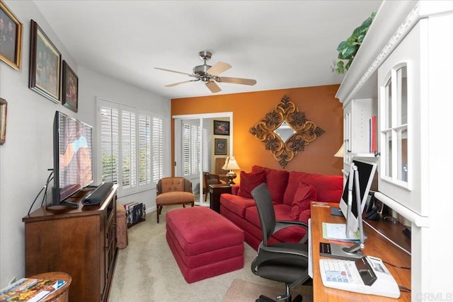 carpeted living room featuring baseboards and ceiling fan