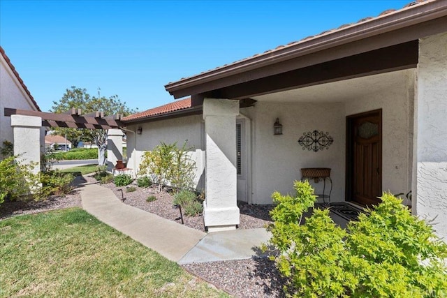 entrance to property featuring stucco siding and a tiled roof