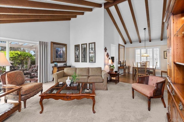 carpeted living room with beamed ceiling and high vaulted ceiling