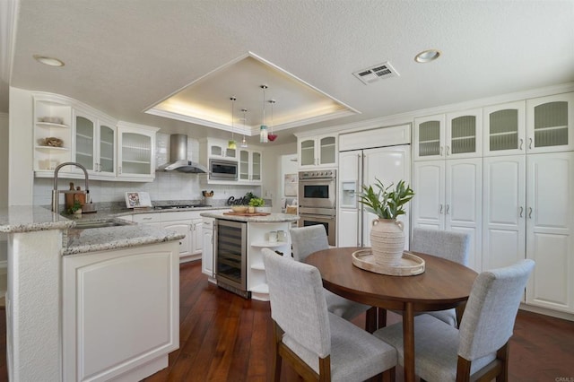 1719 Willowhaven Rd, Encinitas, CA 92024 - kitchen with built in appliances, wall chimney range hood, open shelves, beverage cooler, and a raised ceiling