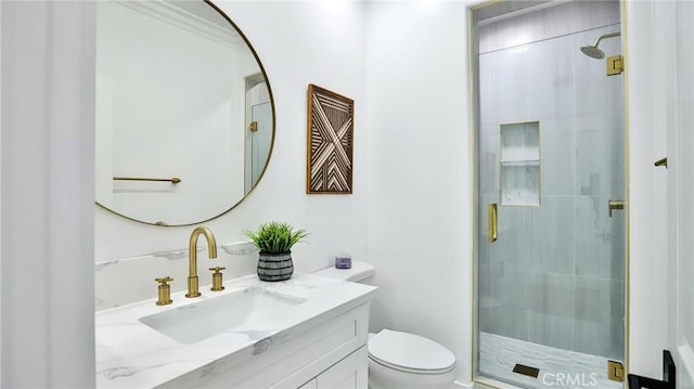 bathroom with toilet, a shower stall, and vanity