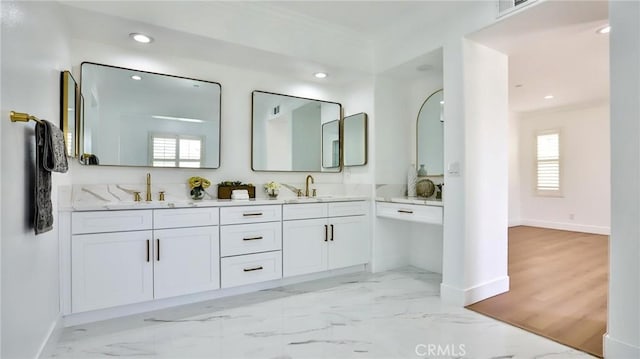 bathroom featuring a sink, baseboards, and a healthy amount of sunlight