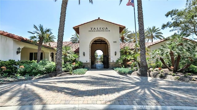 view of exterior entry featuring stucco siding and a tiled roof