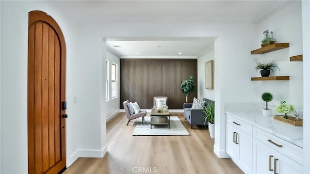 sitting room with crown molding, baseboards, visible vents, and light wood-style floors