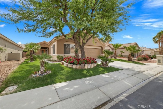 37388 Medjool, Palm Desert, CA 92211 - view of front facade with concrete driveway, an attached garage, stucco siding, a front lawn, and a tiled roof