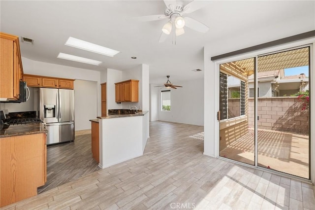 37388 Medjool, Palm Desert, CA 92211 - kitchen with stainless steel fridge, a ceiling fan, range with gas cooktop, light wood-style flooring, and brown cabinets