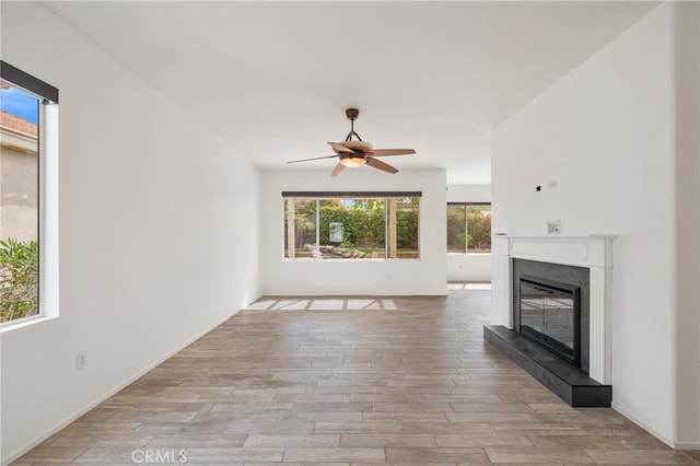37388 Medjool, Palm Desert, CA 92211 - unfurnished living room featuring a glass covered fireplace, ceiling fan, and wood finished floors