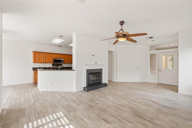 37388 Medjool, Palm Desert, CA 92211 - unfurnished living room with light wood-style flooring, a ceiling fan, and a glass covered fireplace